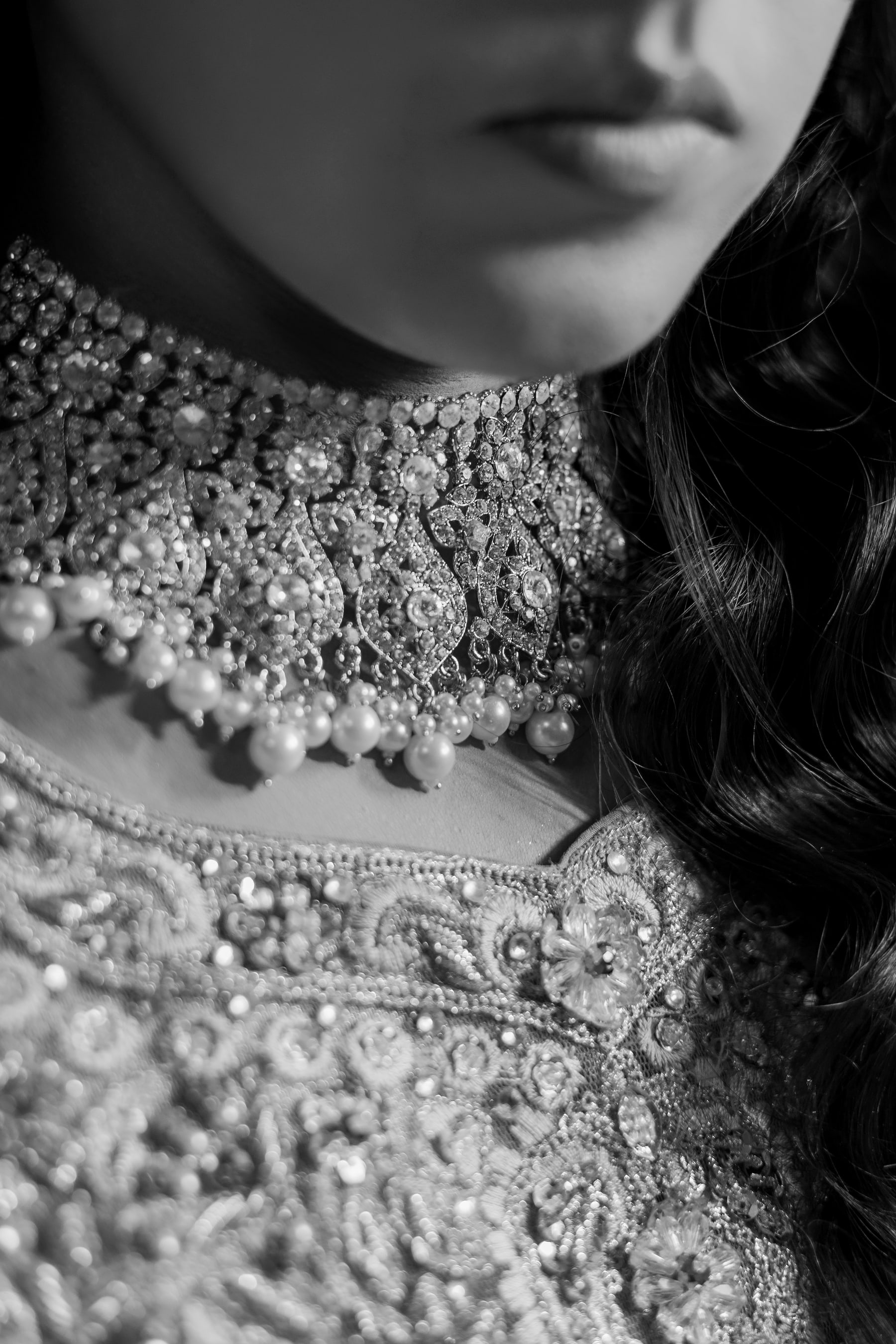Black-and-white close portrait featuring intricate bridal jewelry