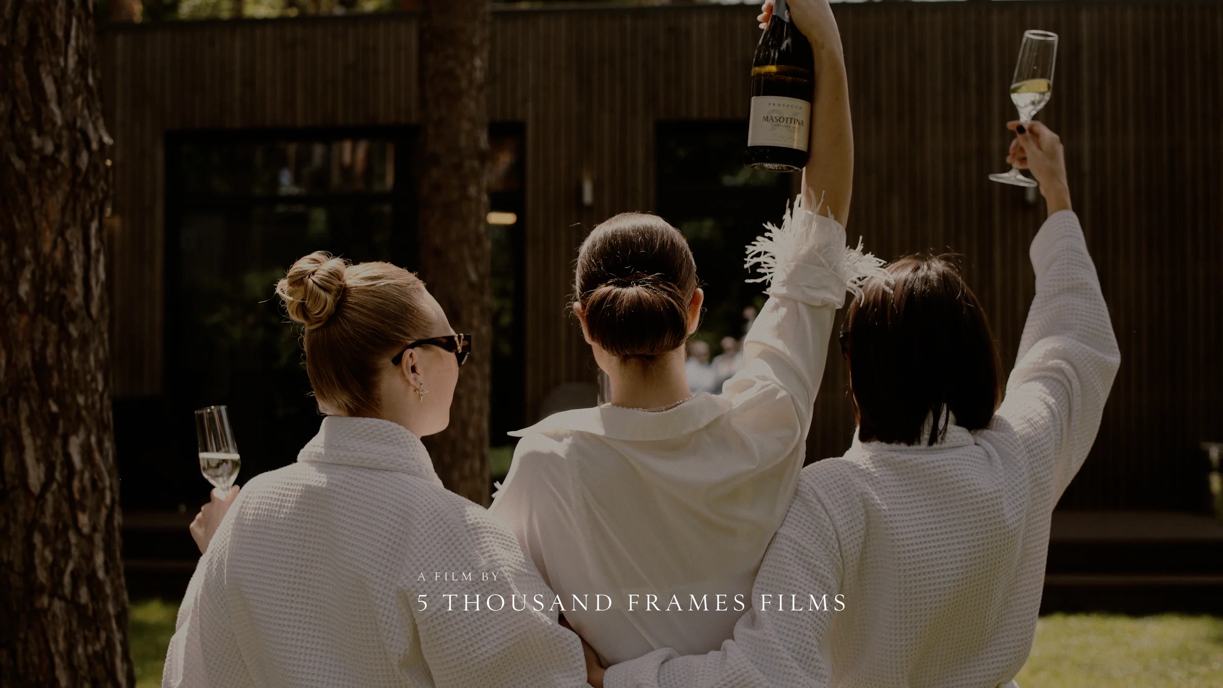 Wedding showreel cover with three women raising glasses in celebration